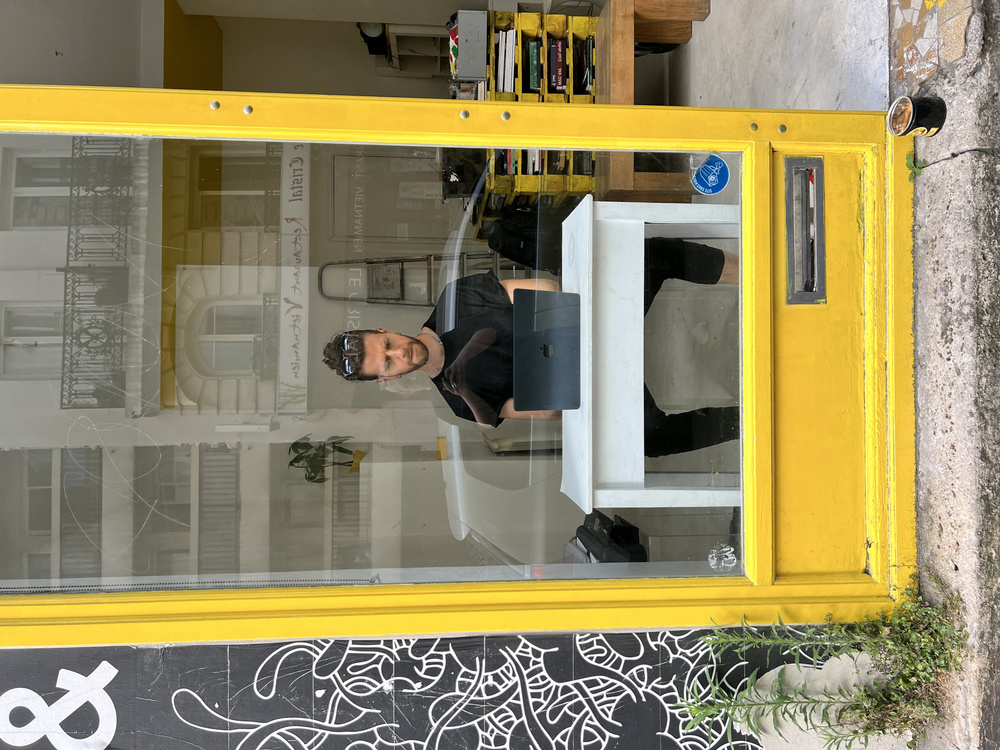Printed poems with pink carnation voting dots laid out on a table