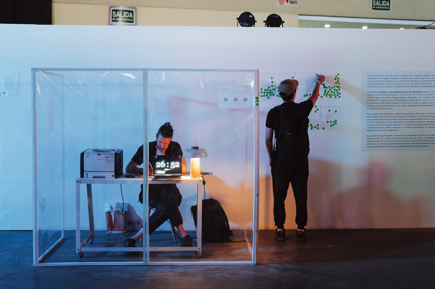 Performer writing on the glass wall of the cube during the performance