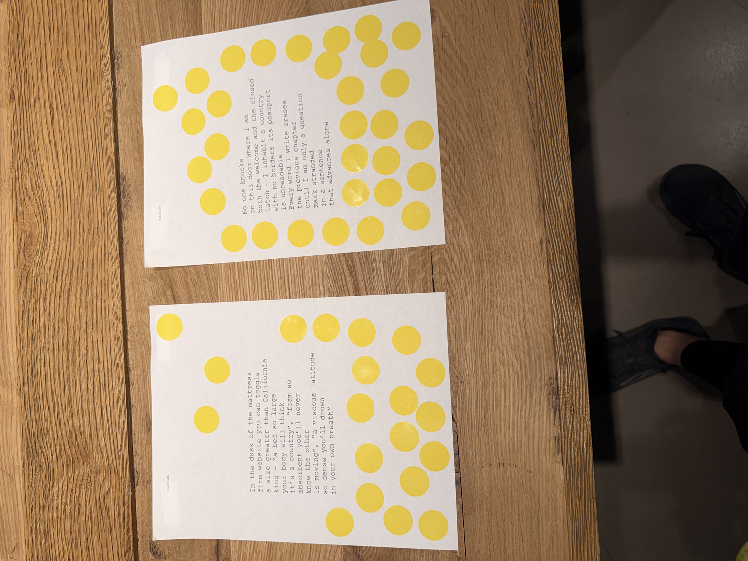 Close-up of two poems side by side with yellow sticker votes